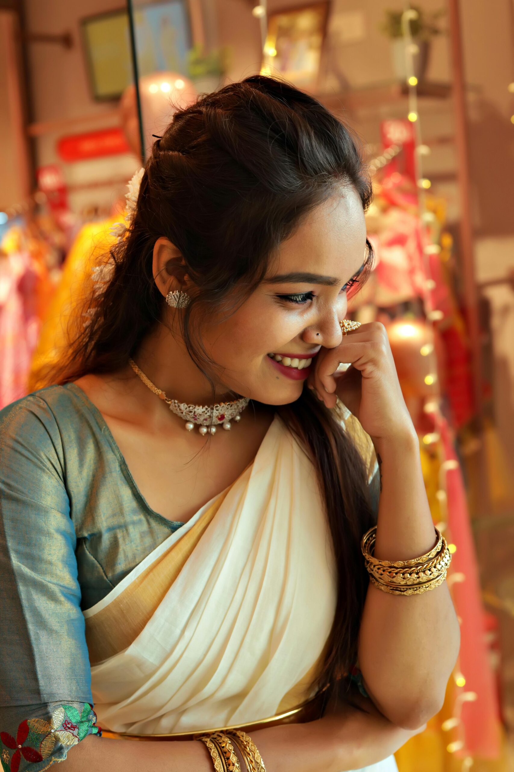 A woman in traditional Indian attire is smiling indoors, creating a joyful atmosphere.